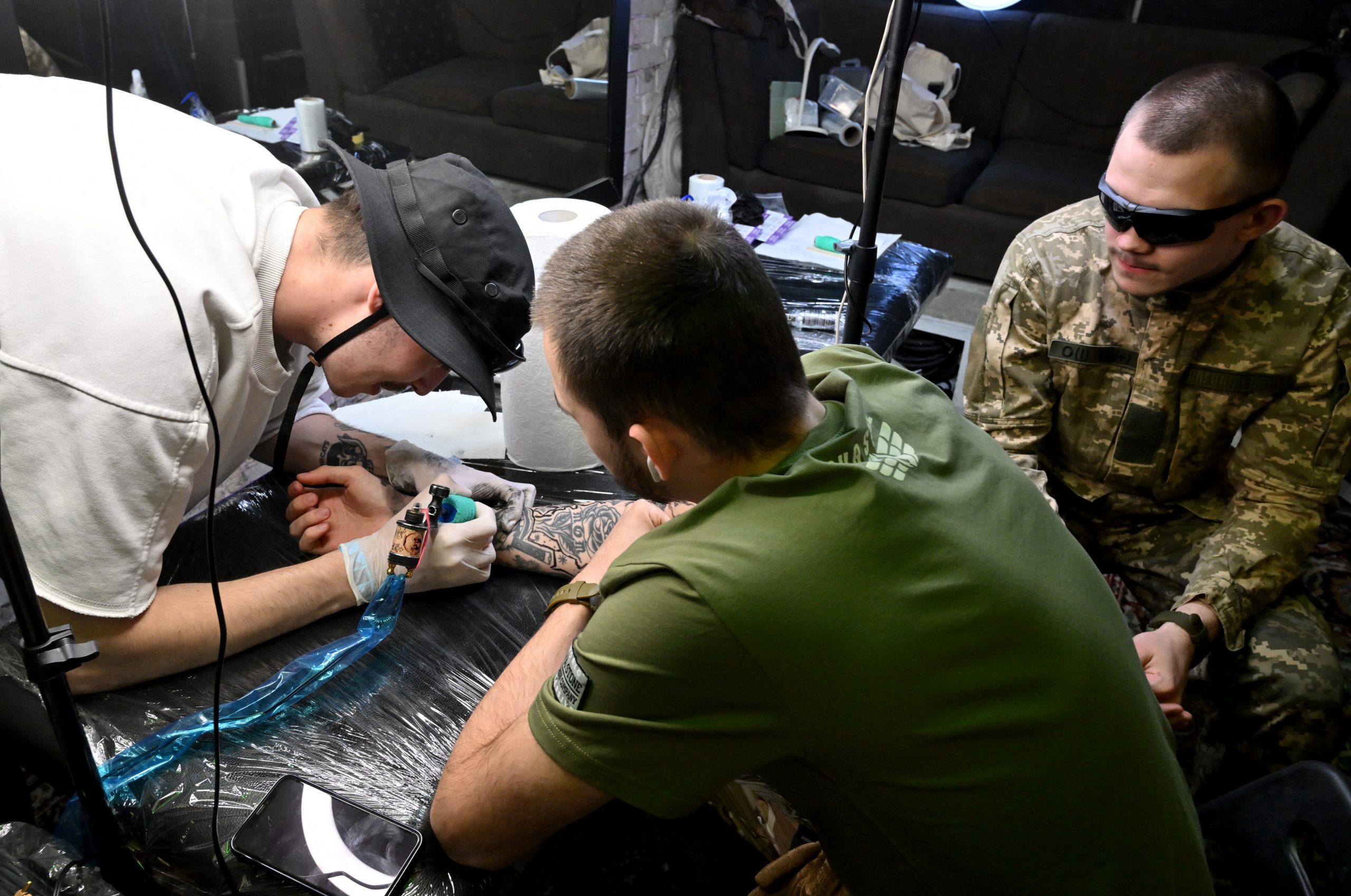 Un militar siendo tatuado en el brazo